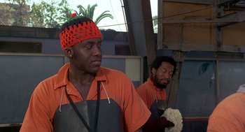 Movie still from “Car Wash” (1976), directed by Michael Schultz – Two men in an orange and black apron and hat; Close Up shot, Low angle