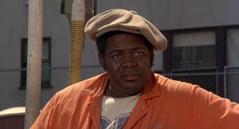Movie still from “Car Wash” (1976), directed by Michael Schultz – A man in an orange jacket and a hat; Close Up shot, Low angle