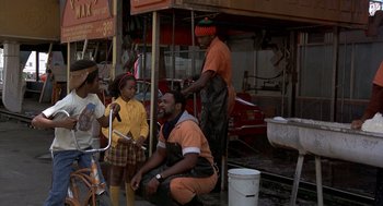 Movie still from “Car Wash” (1976), directed by Michael Schultz – A group of people standing next to each other on the street; Wide shot, High angle
