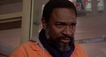 Movie still from “Car Wash” (1976), directed by Michael Schultz – A person wearing an orange jacket; Close Up shot, Low angle