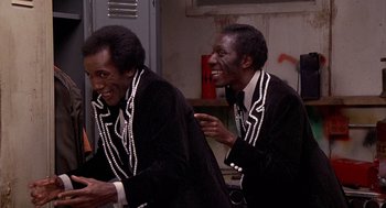 Movie still from “Car Wash” (1976), directed by Michael Schultz – A couple of people that are in a room together; Medium shot, Low angle