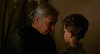 Movie still from “Caravaggio” (1986), directed by Derek Jarman – An older woman and a young boy looking at each other; Close Up shot, Over the shoulder angle