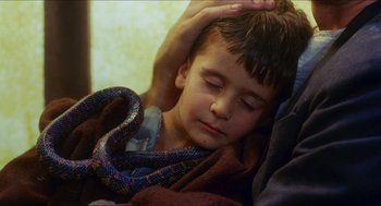 Movie still from “Caravaggio” (1986), directed by Derek Jarman – A young boy sleeping on a blanket with his head on a persons arm; Close Up shot, High angle