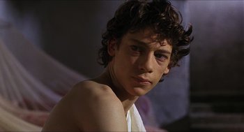 Movie still from “Caravaggio” (1986), directed by Derek Jarman – A young man with a towel around his neck and shoulders; Close Up shot, Low angle