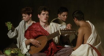 Movie still from “Caravaggio” (1986), directed by Derek Jarman – A group of young men sitting next to each other holding instruments; Medium shot, Over the shoulder angle