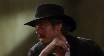 Movie still from “Caravaggio” (1986), directed by Derek Jarman – A person wearing a hat; Close Up shot, Over the shoulder angle