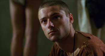 Movie still from “Caravaggio” (1986), directed by Derek Jarman – A person wearing a necklace; Close Up shot, Low angle