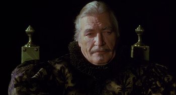 Movie still from “Caravaggio” (1986), directed by Derek Jarman – An older man with a beard and mustache; Close Up shot, Low angle