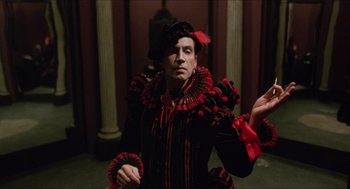 Movie still from “Caravaggio” (1986), directed by Derek Jarman – A man dressed in a red and black costume; Medium shot, Over the shoulder angle
