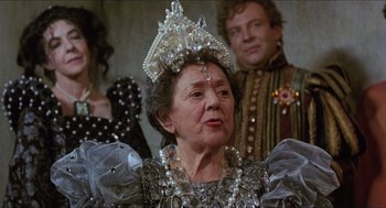 Movie still from “Caravaggio” (1986), directed by Derek Jarman – An older woman wearing a crown and a necklace; Close Up shot, Over the shoulder angle