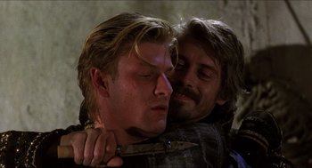 Movie still from “Caravaggio” (1986), directed by Derek Jarman – Two men are hugging each other in the dark; Close Up shot, Over the shoulder angle
