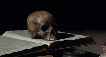Movie still from “Caravaggio” (1986), directed by Derek Jarman – A skull sitting on top of an open book; Extreme Close Up shot, High angle