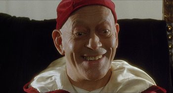 Movie still from “Caravaggio” (1986), directed by Derek Jarman – An older man wearing a red hat and white shirt; Close Up shot, Overhead angle