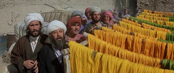 Movie still from “Caravans” (1978), directed by James Fargo – A group of men standing next to each other; Medium shot, High angle
