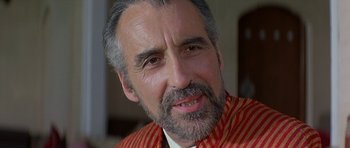 Movie still from “Caravans” (1978), directed by James Fargo – A person wearing a red and white striped shirt; Close Up shot, Over the shoulder angle