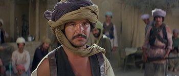 Movie still from “Caravans” (1978), directed by James Fargo – A man with a turban on his head; Close Up shot, Over the shoulder angle