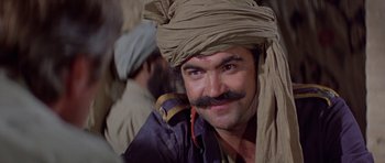 Movie still from “Caravans” (1978), directed by James Fargo – A man with a beard and mustache wearing a turban; Close Up shot, Low angle
