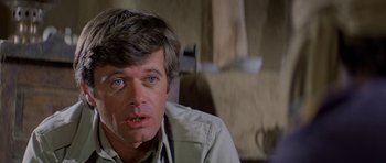 Movie still from “Caravans” (1978), directed by James Fargo – A person wearing a jacket; Close Up shot, Over the shoulder angle