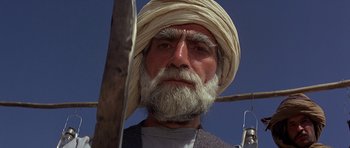Movie still from “Caravans” (1978), directed by James Fargo – An old man with a beard and a turban; Close Up shot, Low angle