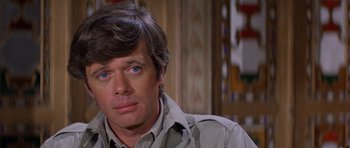 Movie still from “Caravans” (1978), directed by James Fargo – A person wearing a jacket; Close Up shot, Over the shoulder angle