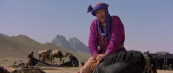 Movie still from “Caravans” (1978), directed by James Fargo – A man sitting on top of a horse in the desert; Medium shot, Low angle