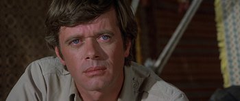 Movie still from “Caravans” (1978), directed by James Fargo – A person wearing a shirt; Close Up shot, Low angle