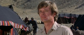 Movie still from “Caravans” (1978), directed by James Fargo – A person wearing a shirt; Close Up shot, Low angle