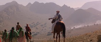 Movie still from “Caravans” (1978), directed by James Fargo – A man riding a horse in the middle of the desert; Extreme Wide shot, High angle