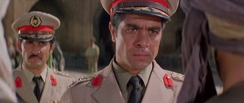 Movie still from “Caravans” (1978), directed by James Fargo – A person wearing a uniform; Close Up shot, Low angle