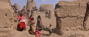 Movie still from “Caravans” (1978), directed by James Fargo – A group of people are running in the desert; Extreme Wide shot, High angle
