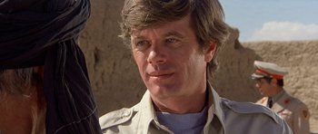 Movie still from “Caravans” (1978), directed by James Fargo – A person holding a gun; Close Up shot, Low angle