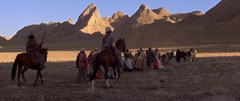 Movie still from “Caravans” (1978), directed by James Fargo – A man riding a horse in the middle of a field; Extreme Wide shot, High angle