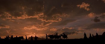 Movie still from “Caravans” (1978), directed by James Fargo – A group of people riding horses on top of a hill; Extreme Wide shot, Low angle