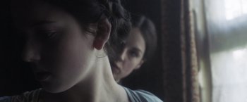 Movie still from “Carmilla” (2019), directed by Emily Harris – A woman is looking at her reflection in a mirror; Close Up shot, Over the shoulder angle