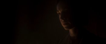 Movie still from “Carmilla” (2019), directed by Emily Harris – A woman is looking at the camera in the dark; Close Up shot, Low angle
