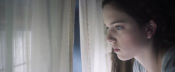 Movie still from “Carmilla” (2019), directed by Emily Harris – A woman looking out of a window at night; Close Up shot, Low angle