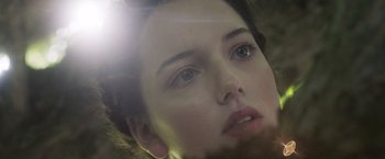 Movie still from “Carmilla” (2019), directed by Emily Harris – A woman's face with the sun glaring in the background; Extreme Close Up shot, Low angle