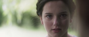 Movie still from “Carmilla” (2019), directed by Emily Harris – A woman's face with a blurry background; Close Up shot, Over the shoulder angle