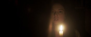 Movie still from “Carmilla” (2019), directed by Emily Harris – A woman with a candle in a dark room; Close Up shot, Over the shoulder angle