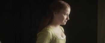Movie still from “Carmilla” (2019), directed by Emily Harris – A young woman in a green shirt looking to the side; Close Up shot, Over the shoulder angle
