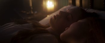 Movie still from “Carmilla” (2019), directed by Emily Harris – A woman laying in a bed with her eyes closed; Close Up shot, Over the shoulder angle
