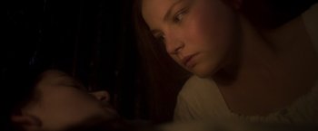 Movie still from “Carmilla” (2019), directed by Emily Harris – A woman looking down at her cell phone in the dark; Close Up shot, Over the shoulder angle