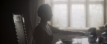 Movie still from “Carmilla” (2019), directed by Emily Harris – A woman sitting at a table with a bowl of food; Medium shot, Over the shoulder angle