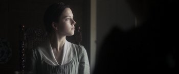A young woman is looking into a mirror