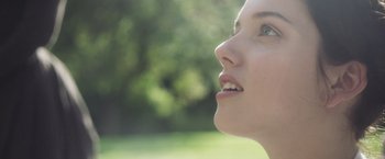 Movie still from “Carmilla” (2019), directed by Emily Harris – A woman's face in a park setting; Close Up shot, Low angle