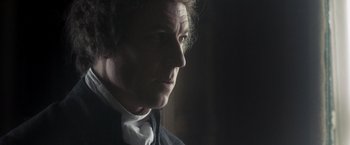 Movie still from “Carmilla” (2019), directed by Emily Harris – A person wearing a suit and tie; Close Up shot, Over the shoulder angle