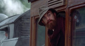 Movie still from “Carrington” (1995), directed by Christopher Hampton – A man with a beard wearing a hat and glasses; Close Up shot, Low angle
