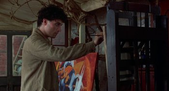 Movie still from “Carrington” (1995), directed by Christopher Hampton – A young man is painting a picture on a wall; Medium shot, Low angle