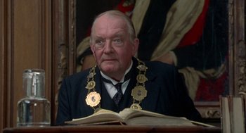 Movie still from “Carrington” (1995), directed by Christopher Hampton – An older man wearing a suit and tie; Close Up shot, Low angle