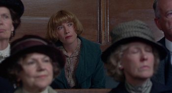 Movie still from “Carrington” (1995), directed by Christopher Hampton – A woman sitting in front of other women in a room; Close Up shot, Low angle